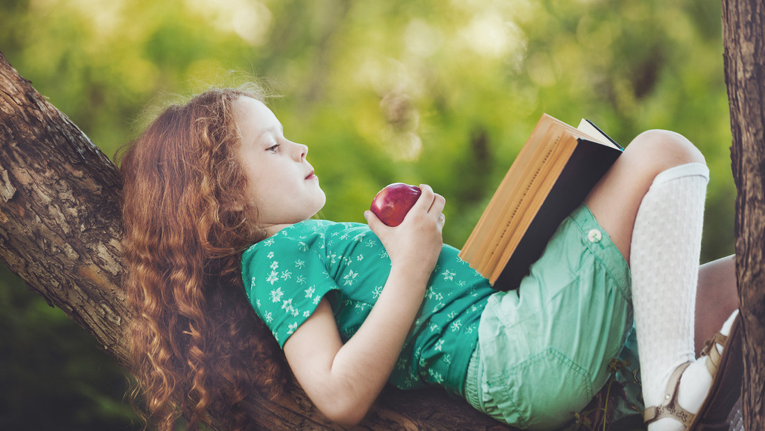 Mädchen mit Apfel liest Buch