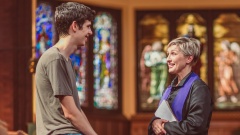 Priesterin spricht mit jungem Mann in Kirche