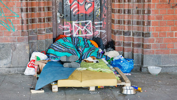 Obdachlose Person schläft auf einer Matratze auf der Straße