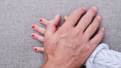 Männerhand liegt auf einer Mädchenhand (gestellte Szene)