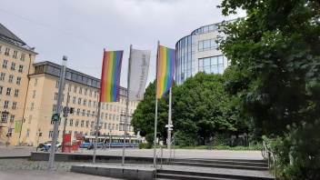 Regenbogenfahnen vor einem internationalen Pharma-Unternehmen an der Hackerbrücke in München