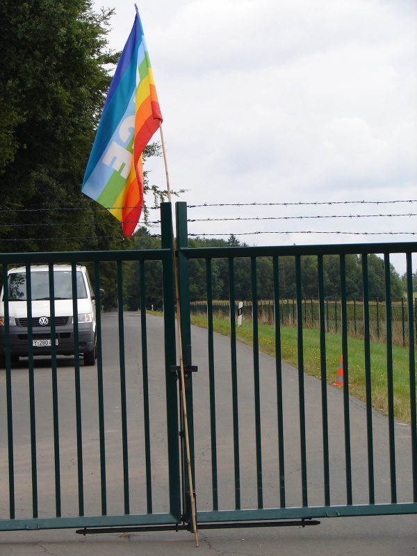 Fahne der Friedensbewegung an einem Tor zu einem Bundeswehrstützpunkt.